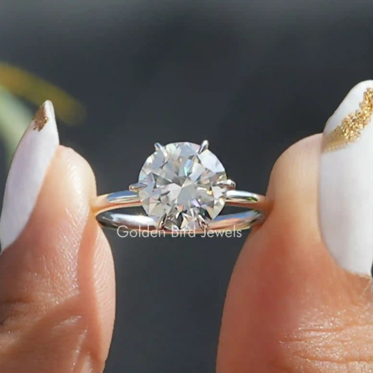 Two fingers holding the Round Cut Moissanite Solitaire Engagement Ring