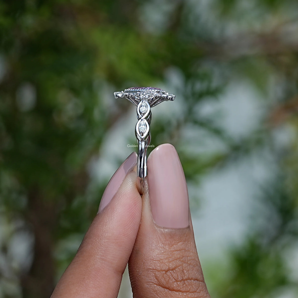 Side View of Pink Pear Cut Gemstone Ring In two fingers
