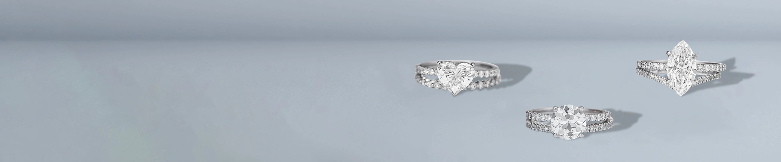 Lab grown bridal ring sets with round and cushion diamonds on light blue background