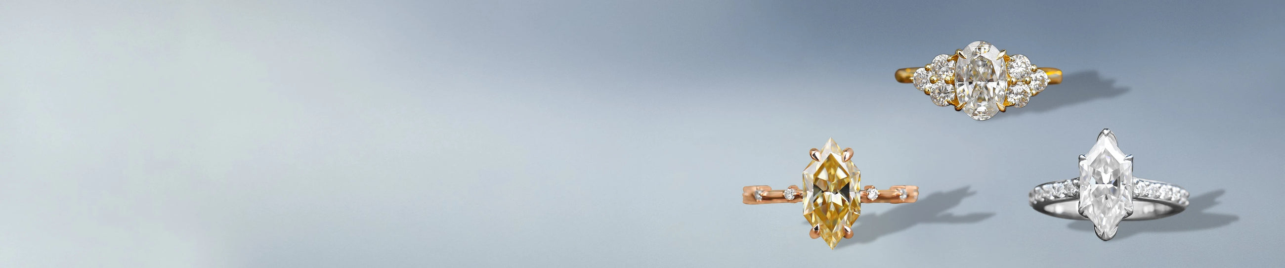 Moissanite rings with accent stones displayed on a soft blue background