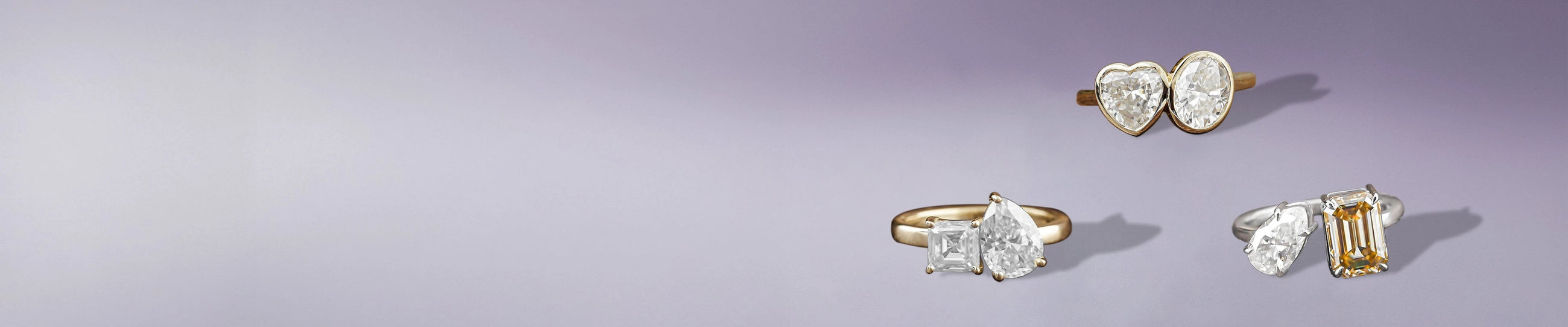Two stone moissanite rings featuring heart, pear, oval, and emerald-cut gems in elegant styles