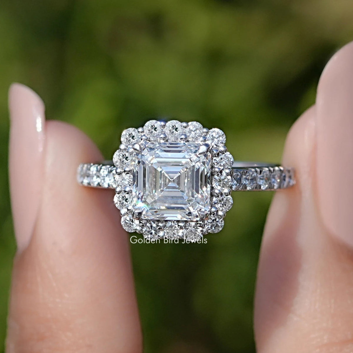 Front view of Asscher Cut Lab Diamond Accent Halo Wedding Ring in two fingers 