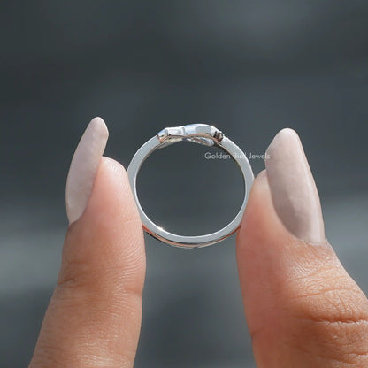 Back View of Ribbon Round Cut White Gold Ring in two fingers