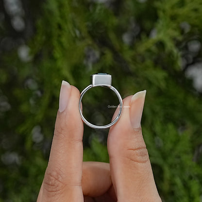 Silver solitaire ring viewed from the back, showing the circular band and raised bezel setting
