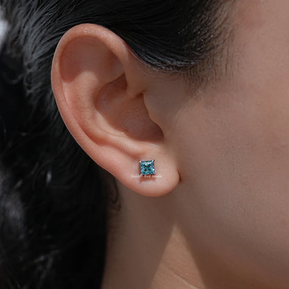 Blue princess-cut screw-back stud earring on side profile ear