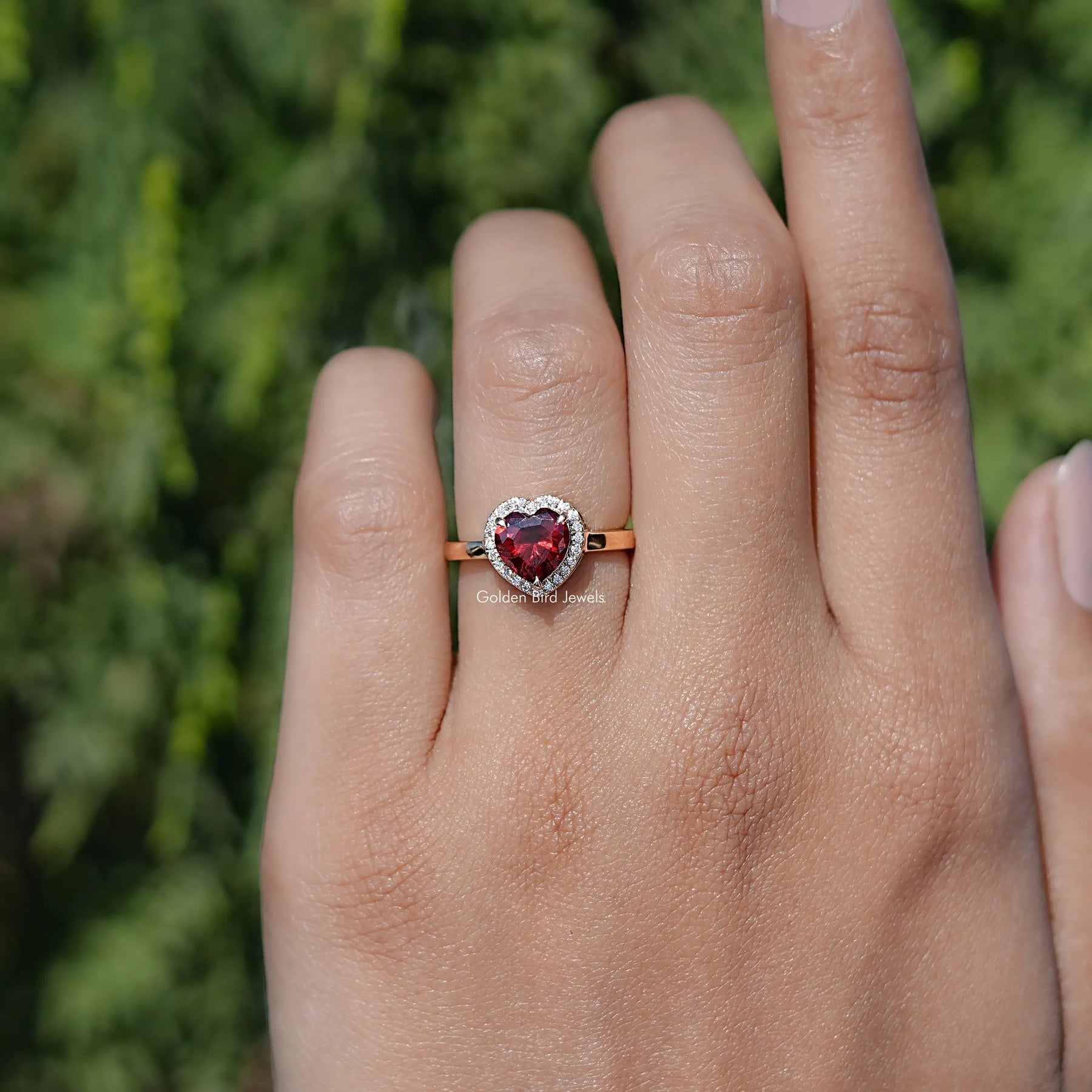 In finger front view of Red Ruby Heart engagement ring 

