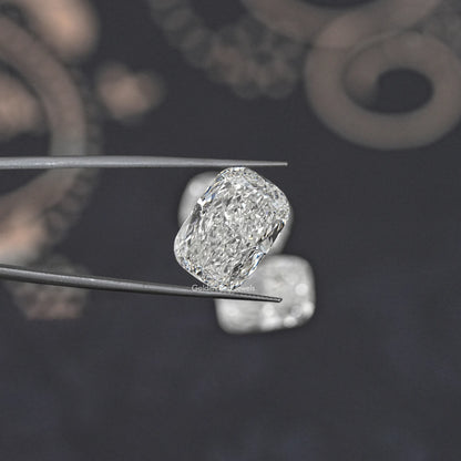 Elongated cushion-cut loose diamond on metal tweezers, faceted