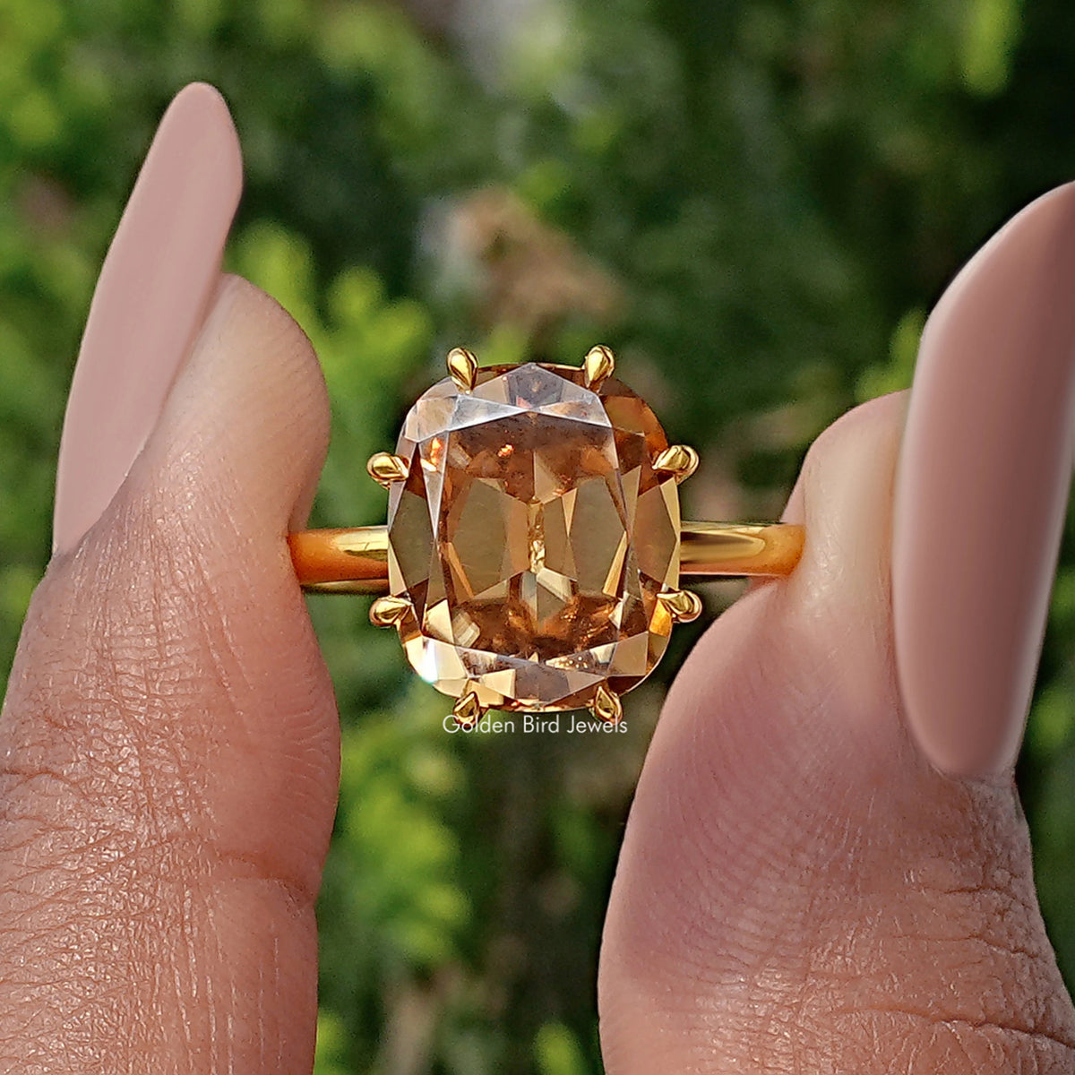 Champagne cushion-cut moissanite ring close-up with gold prongs around stone
