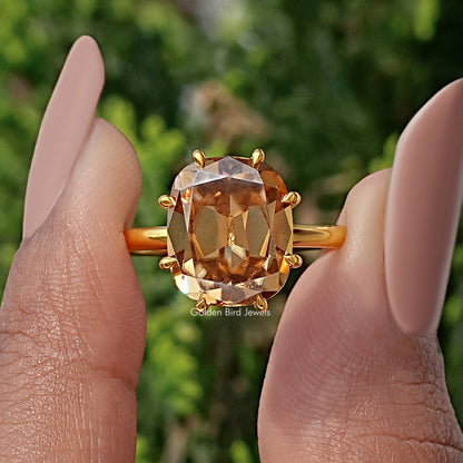Champagne cushion-cut moissanite ring close-up with gold prongs around stone