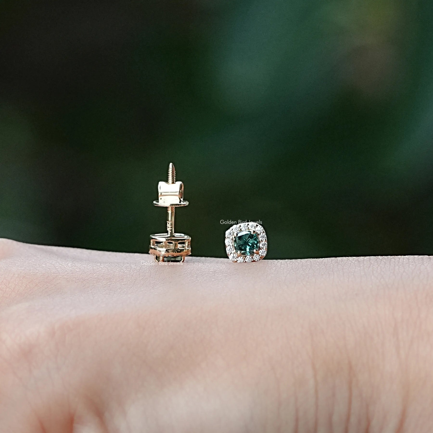 In hand view of moissanite stud earrings in unique shape
