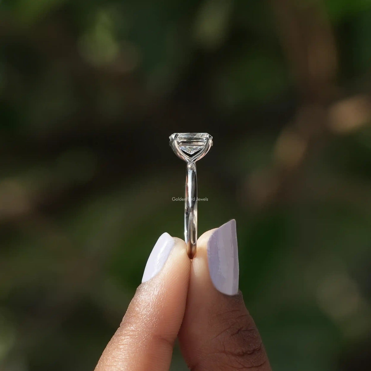 Side View of Cushion Cut Solitaire Engagement Ring In two fingers