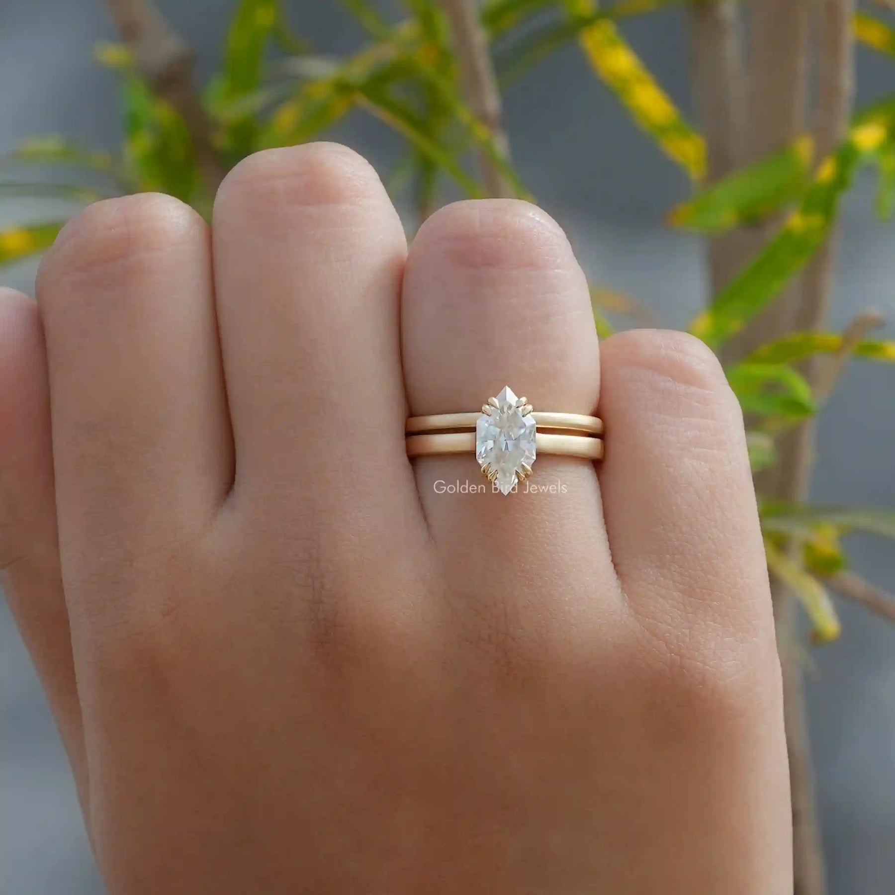 In finger view of halo moissanite engagement ring in yellow gold 