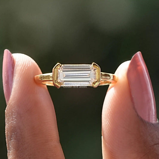 Emerald-cut solitaire ring with east-west stone, gold-tone prong setting and band