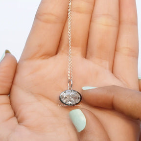 In hand showing view of moissanite pendant in prongs setting