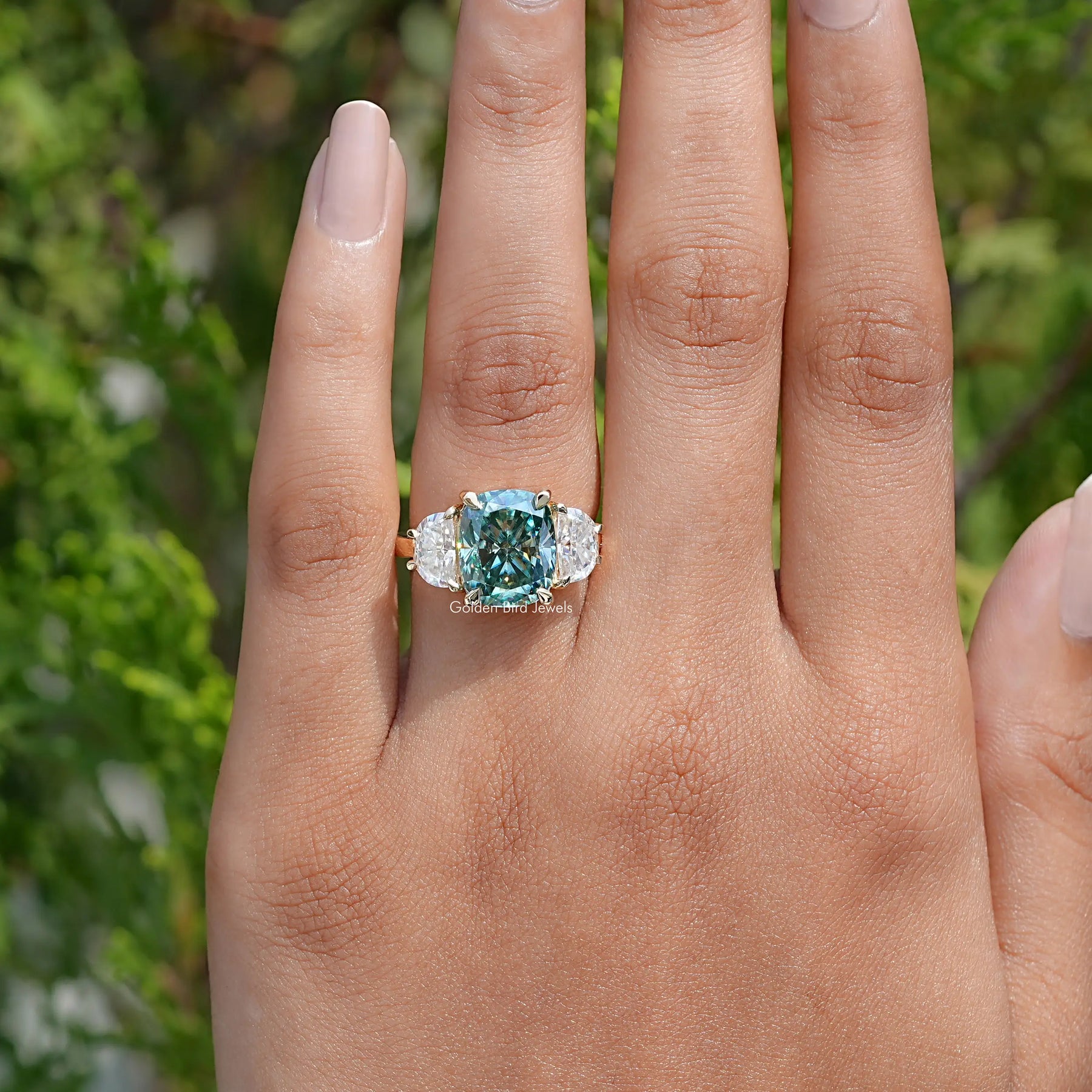 In front finger View Of Cushion Cut Moissanite Three Stone Ring