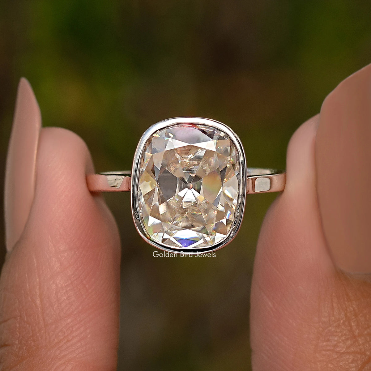 Sterling silver elongated cushion moissanite ring close-up with reflective bezel frame