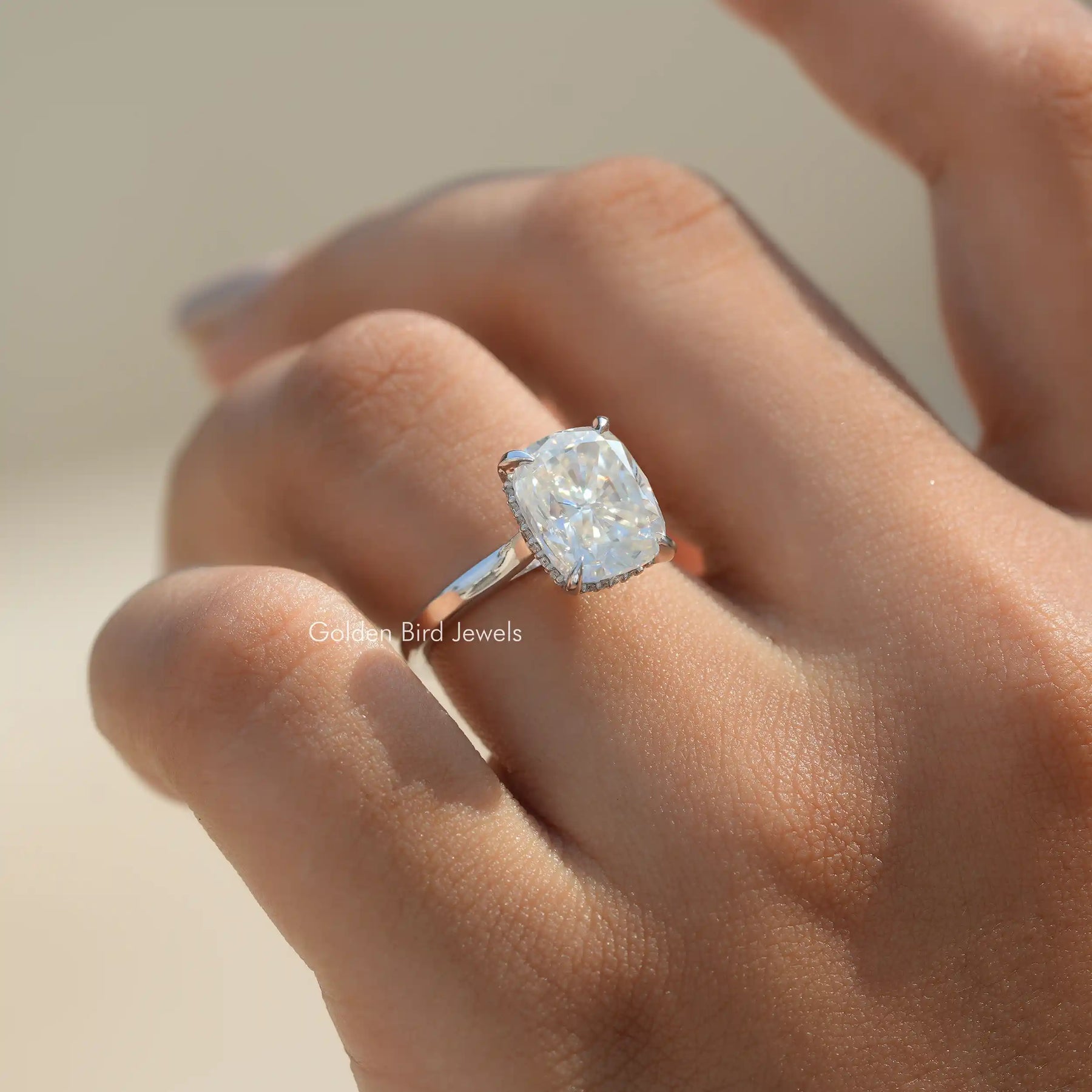 In finger front view of Elongated Cushion Lab Diamond Hidden Halo Ring in unique shape