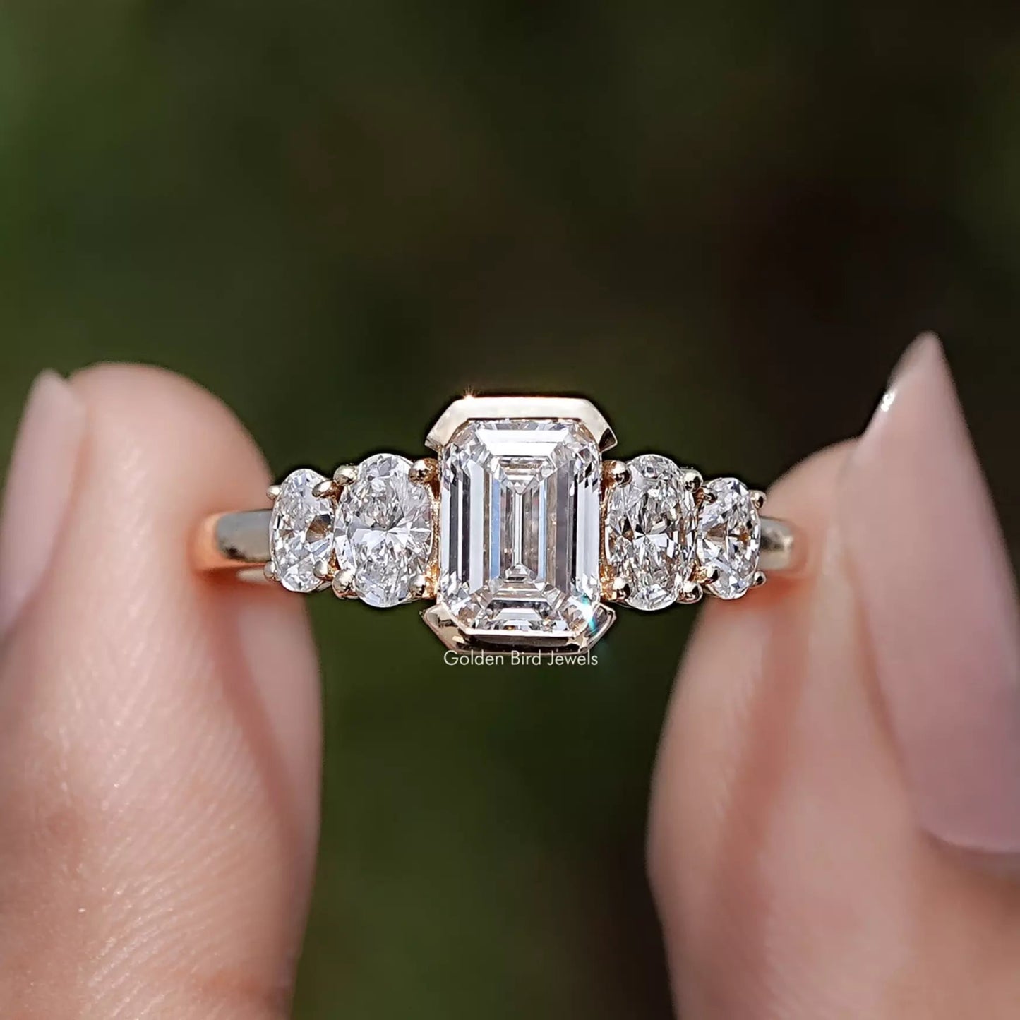 Pear And Baguette Cut Lab Diamond Five Stone Ring Between Two Fingers