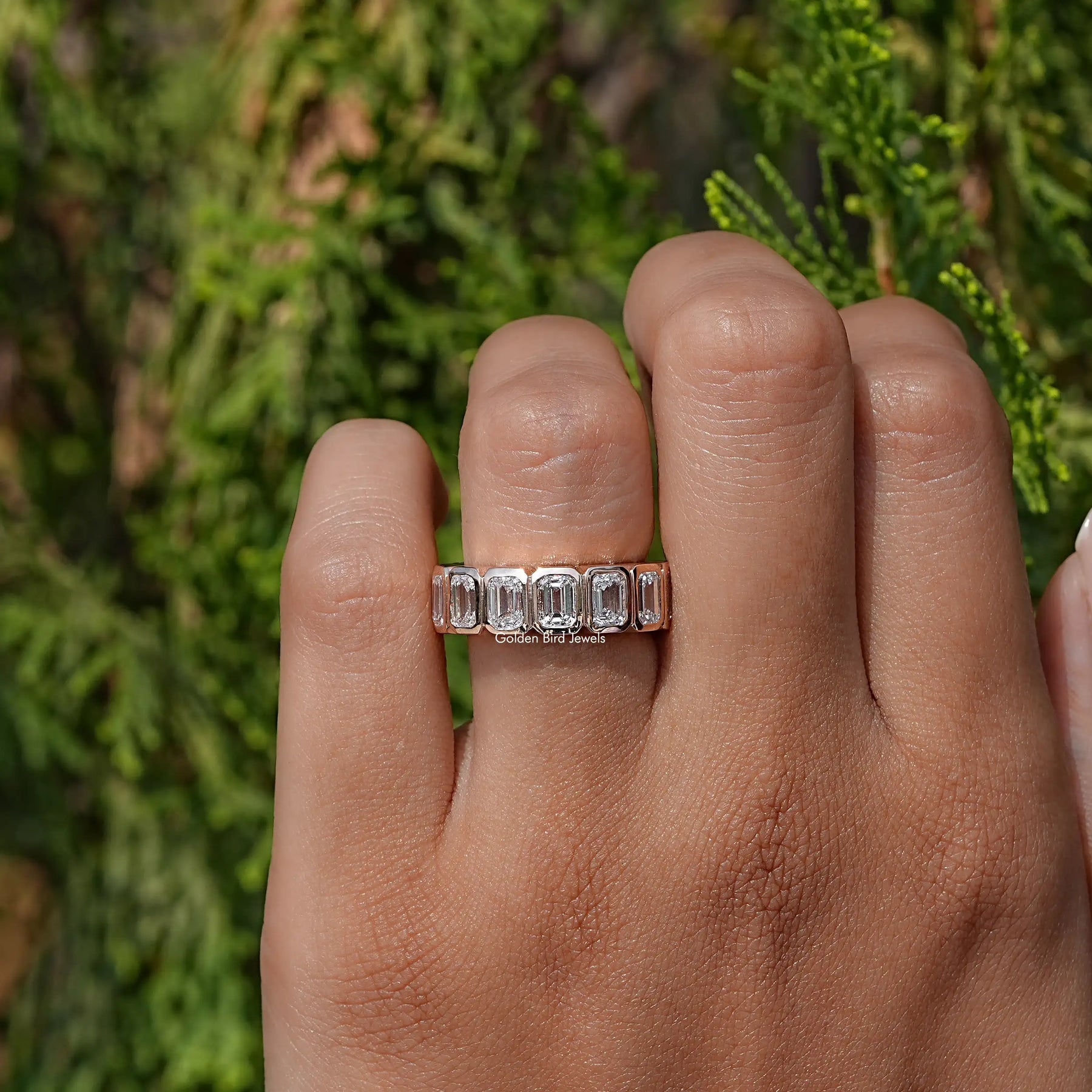 Close-Up View of Emerald Cut Diamond Bezel Set Eternity Band In Yellow Gold
