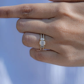 In finger front view of Emerald shape moissanite wedding ring in unique shape
