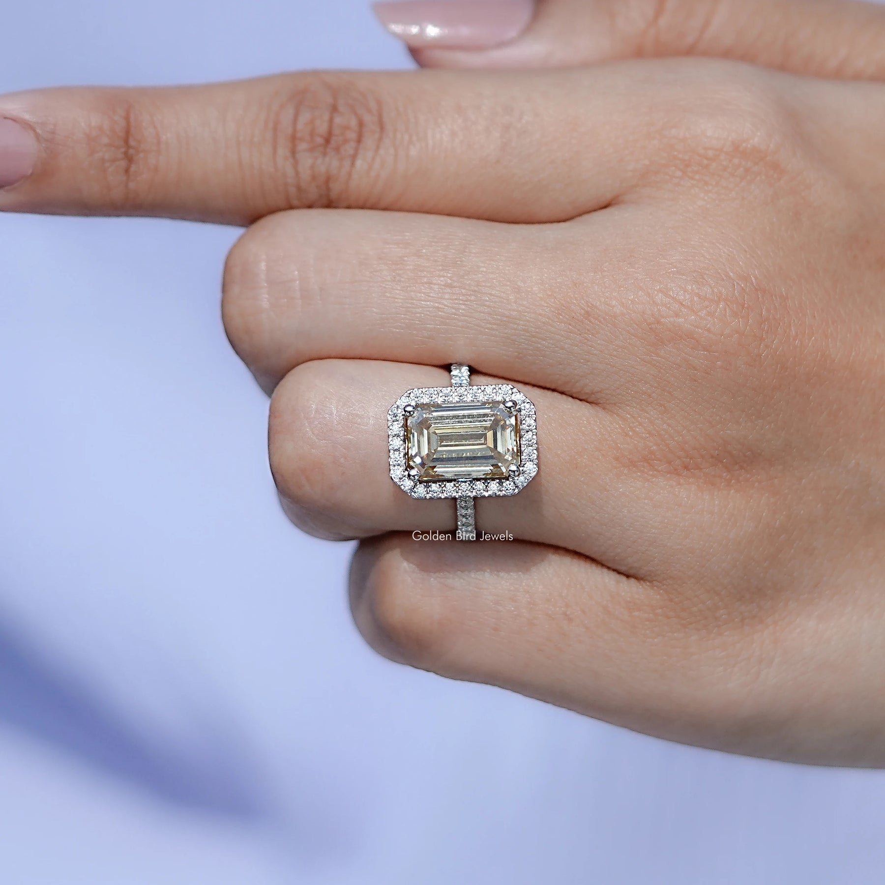 In finger front view of Emerald Cut moissanite wedding ring in unique shape