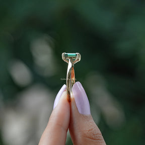 Side view of moissanite ring holding on two fingers 