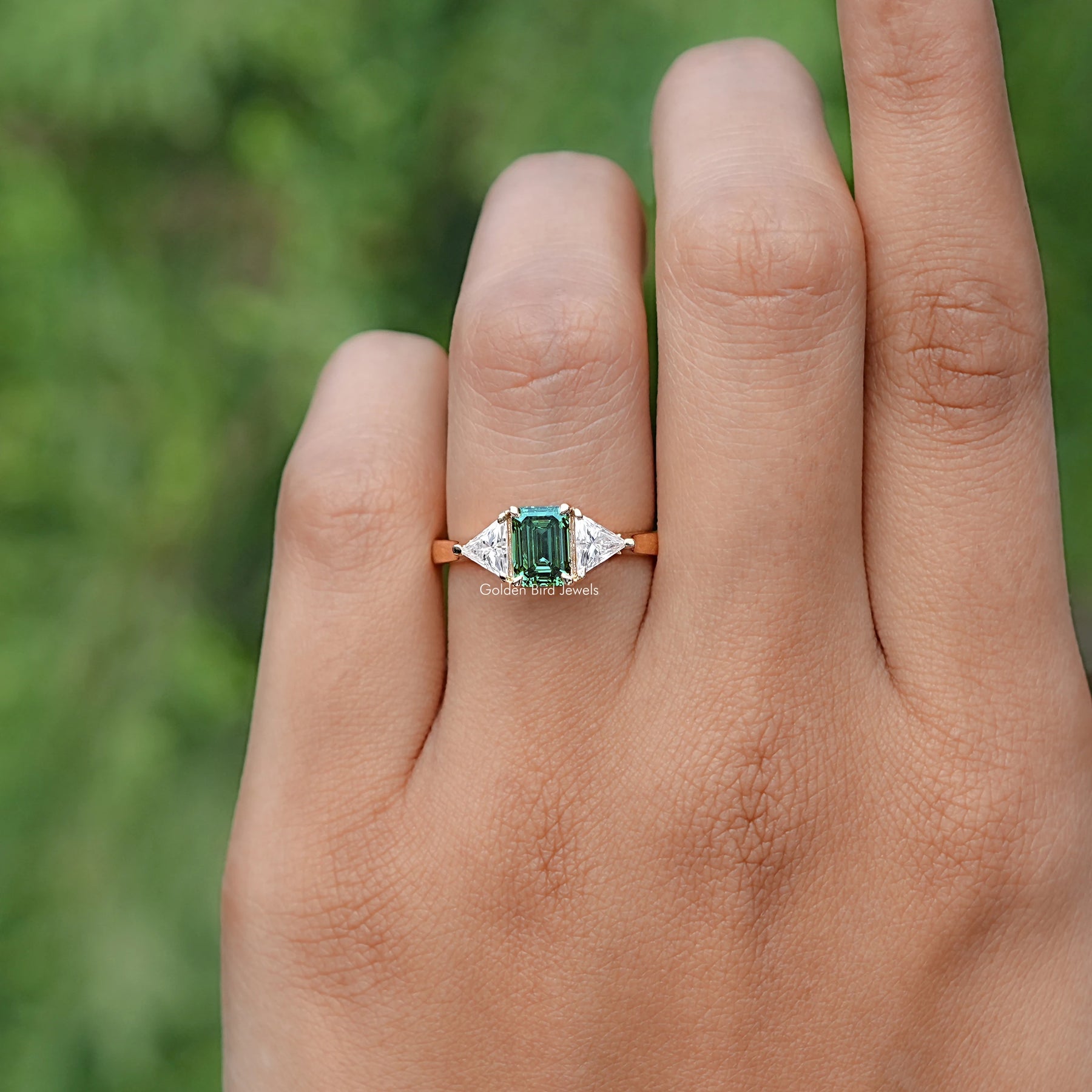 In finger front view of Blue Green Radiant Cut Moissanite engagement ring 