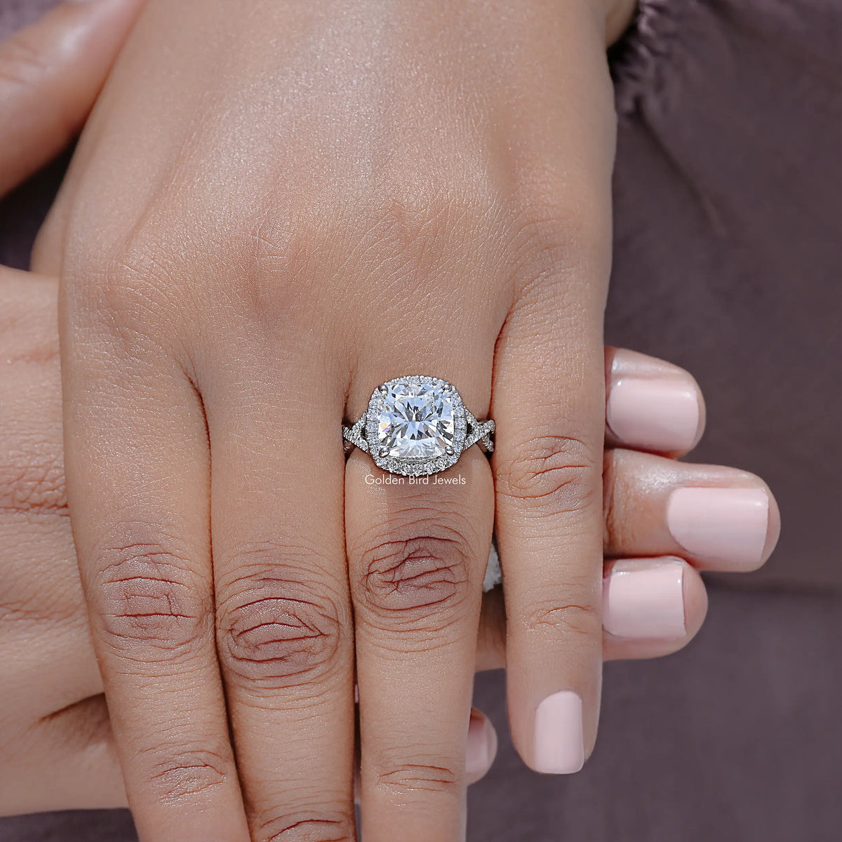 Close-up of oval lab diamond halo engagement ring on twisted silver band