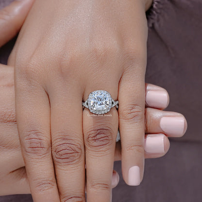 Close-up of oval lab diamond halo engagement ring on twisted silver band