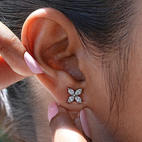 In detailed ear view of flower style stud diamond earings 