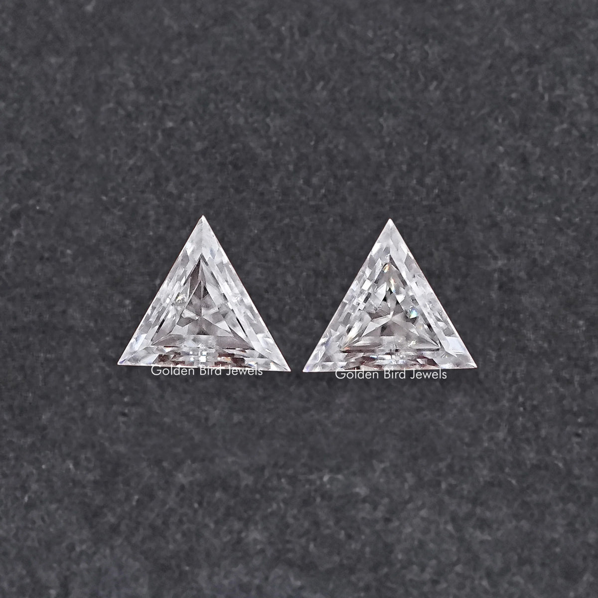 Two triangle-cut clear moissanite stones, faceted front view