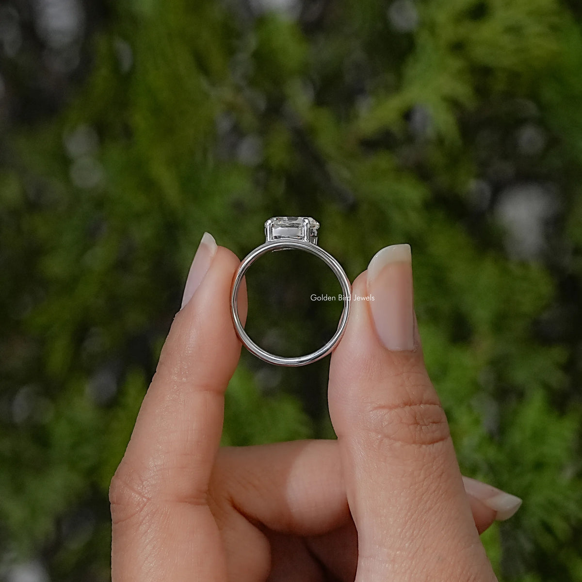 Sterling silver ring shown from the side, with a raised oval stone setting and curved band