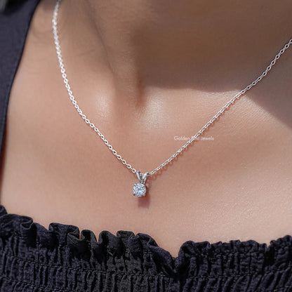 Silver round moissanite pendant necklace resting at the collar over a ruffle top