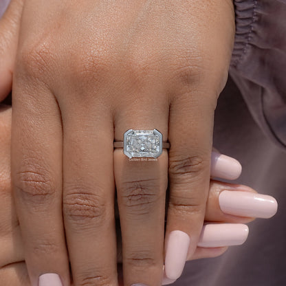 Silver half-bezel solitaire ring with square radiant-cut stone on open hand