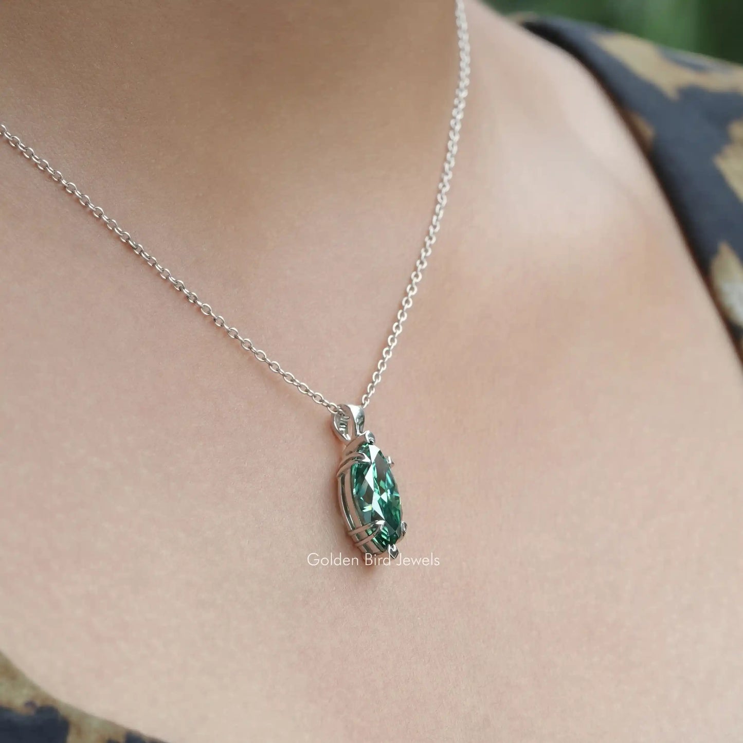 Side view of green marquise pendant In white Gold
