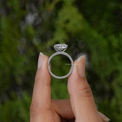Side view of the silver ring band and raised pear-cut moissanite setting