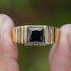 Princess Cut Black Gemstone Solitaire Men’s Ring Held Between Fingers