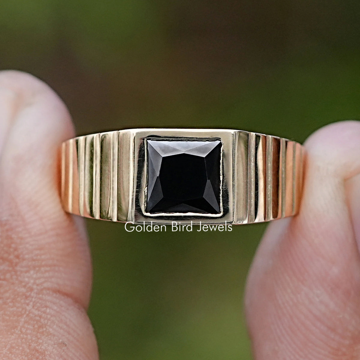 Princess Cut Black Gemstone Solitaire Men’s Ring Held Between Fingers
