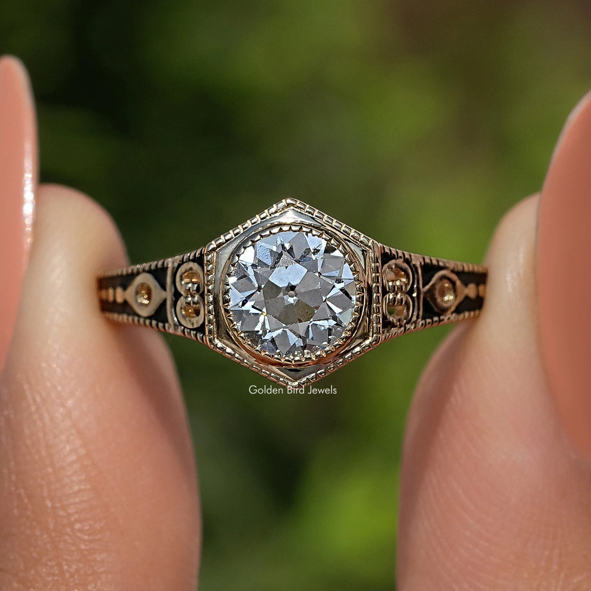 Close-up of round diamond in an ornate bezel with detailed hexagonal-pattern band