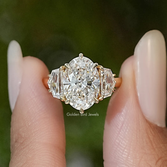 Three-stone diamond engagement ring, oval center with baguette sides, yellow gold