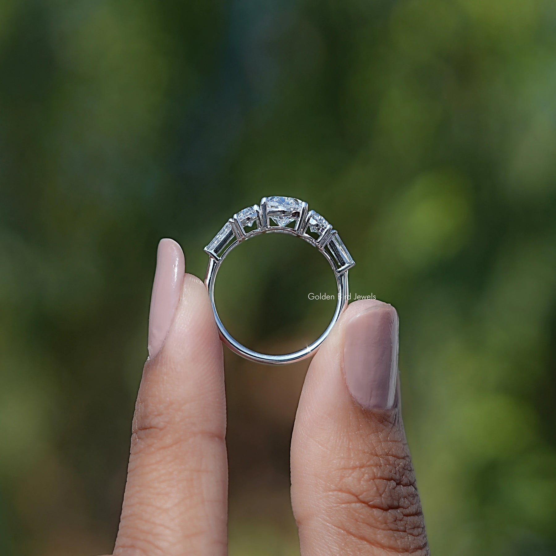 Back View of Oval And Tapered Baguette Cut Diamond Five Stone Ring In two fingers