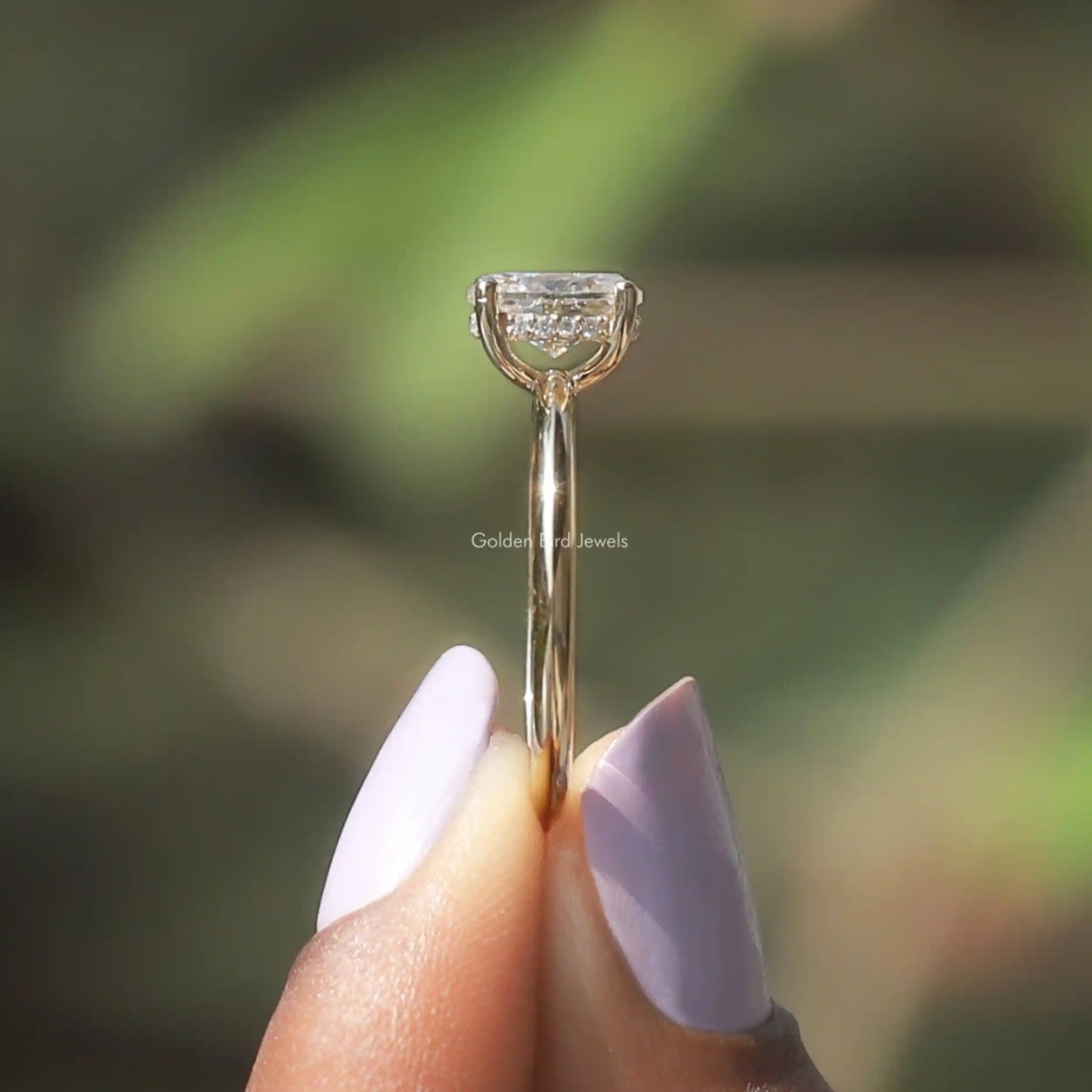 Side View of Oval Cut Moissanite Halo Ring In two fingers
