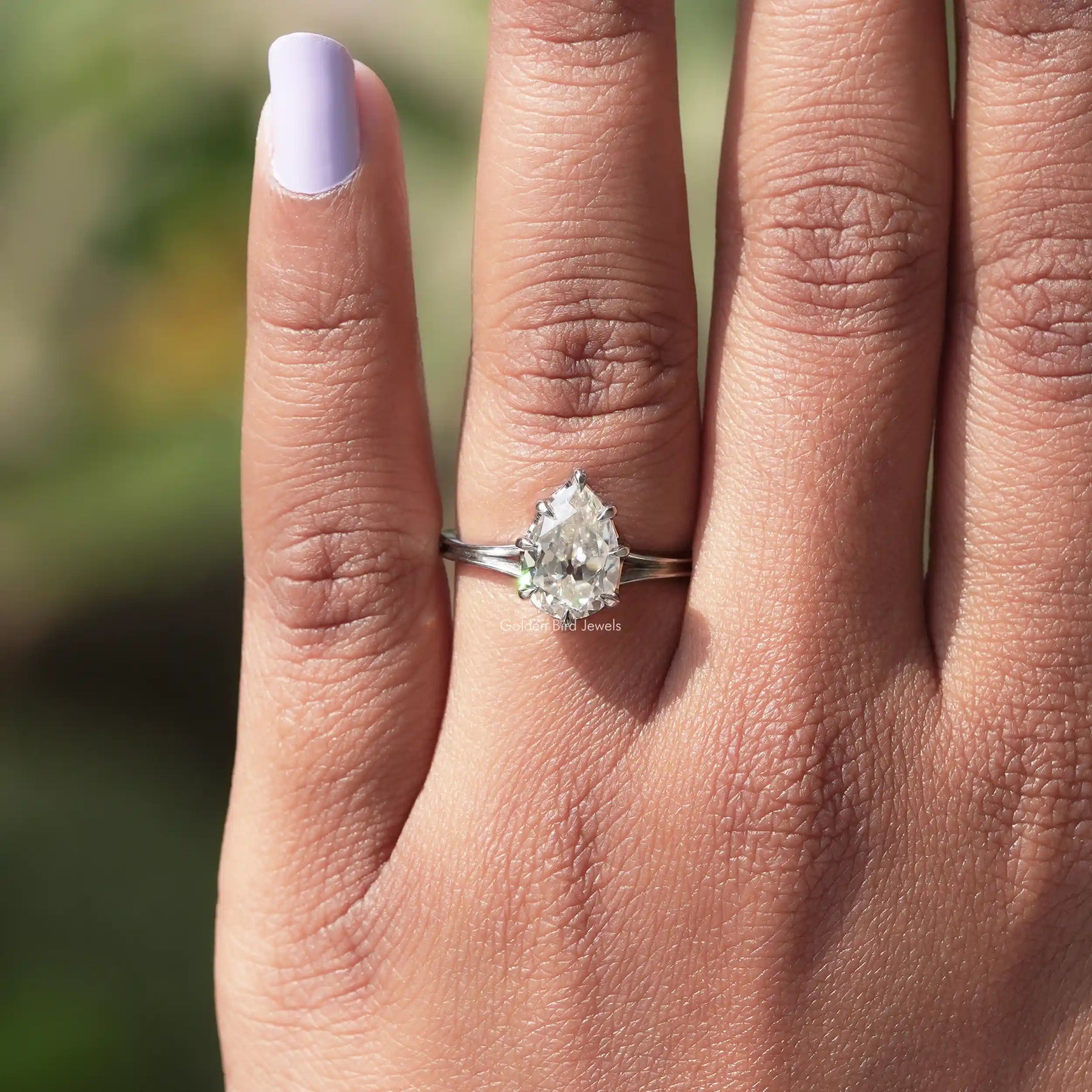 View of solitaire pear moissanite  ring in prongs setting 