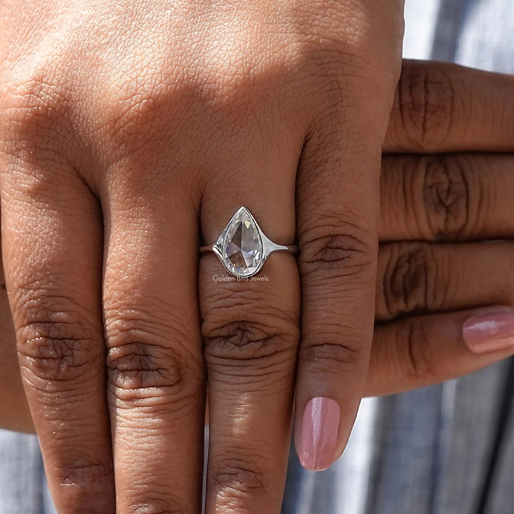 Close-Up View of Pear Cut Bezel Set Moissanite Ring In White Gold       