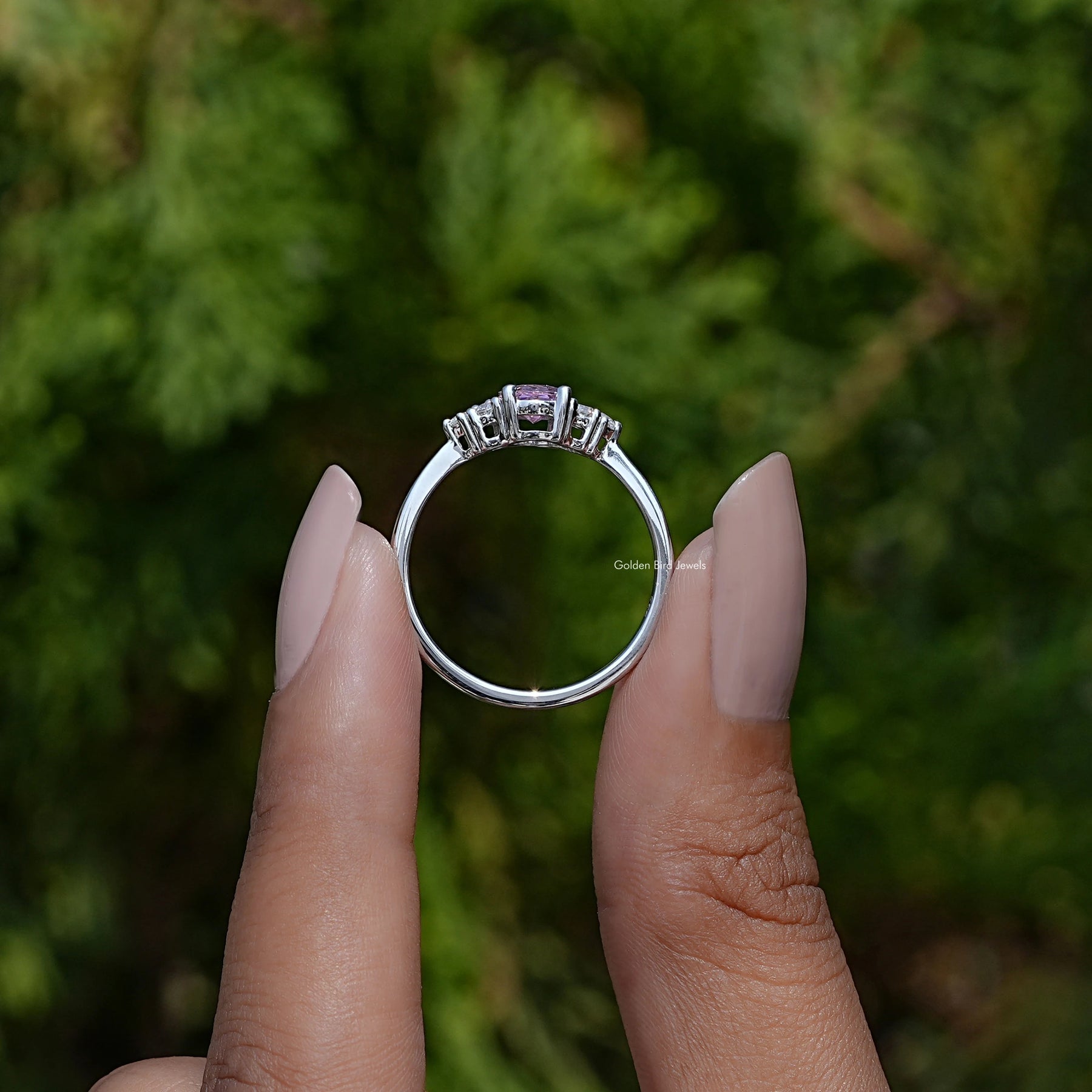 Back View of Oval Cut Gemstone Engagement Ring In two fingers