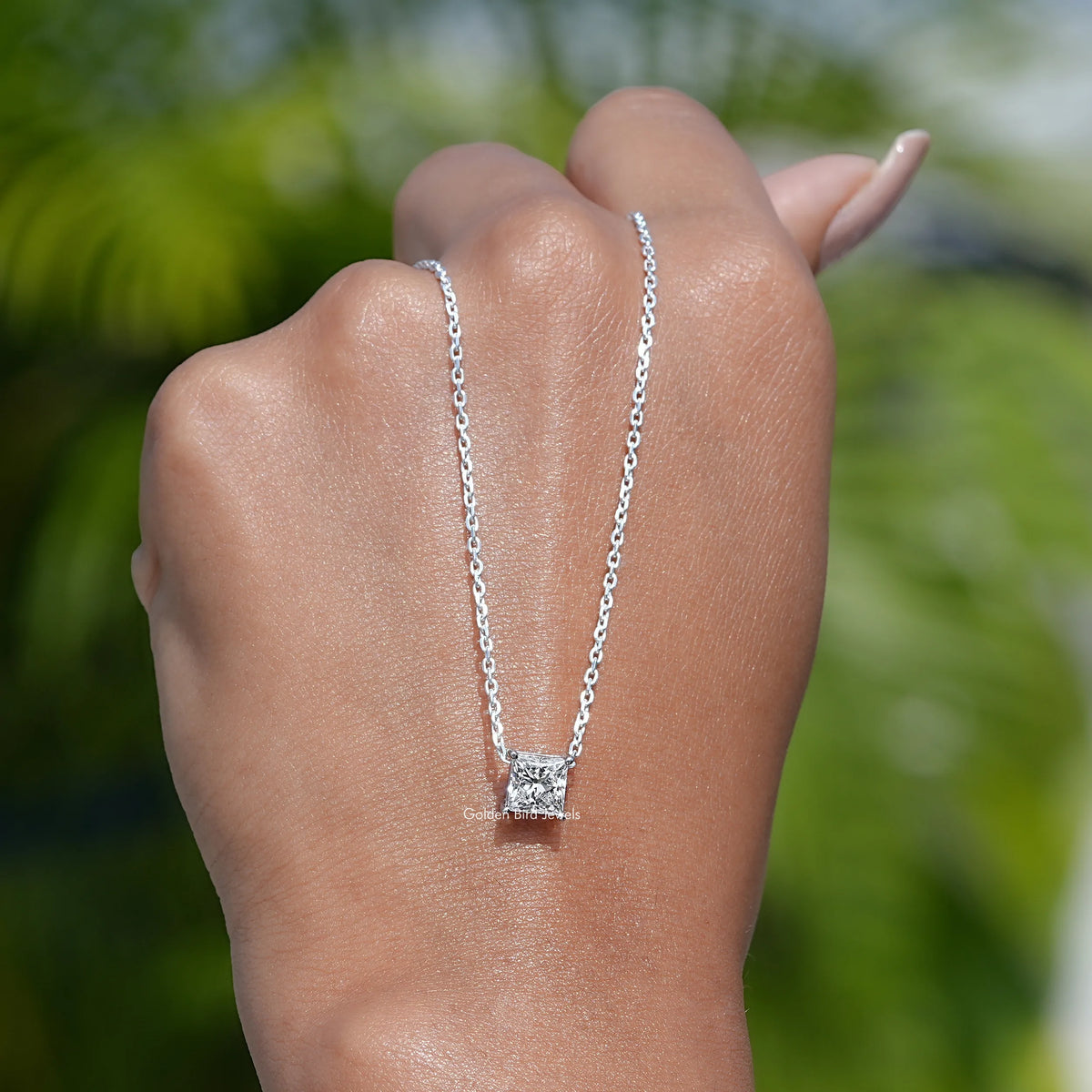 In hand showing view of diamond pendant