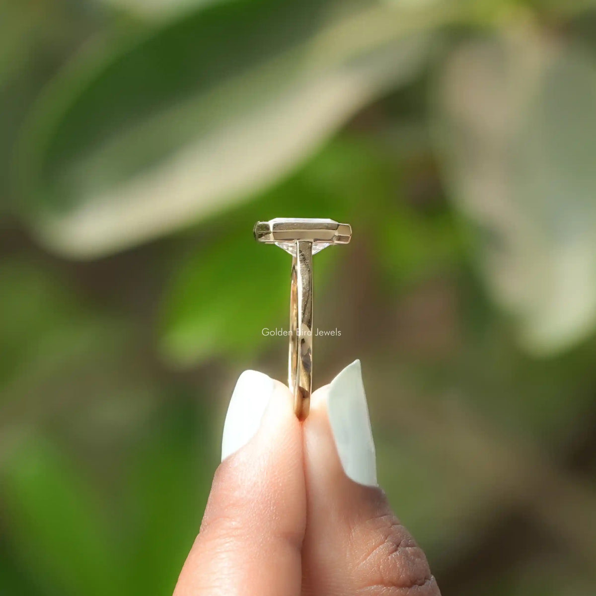 Side View of Radiant Cut Diamond Bezel Set Solitaire Ring In two fingers