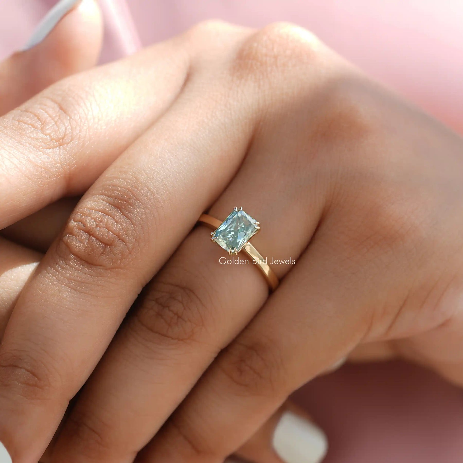 Clear View of Blue Radiant Cut Solitare Engagement Ring in a finger
