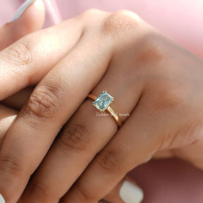 Clear View of Blue Radiant Cut Solitare Engagement Ring in a finger