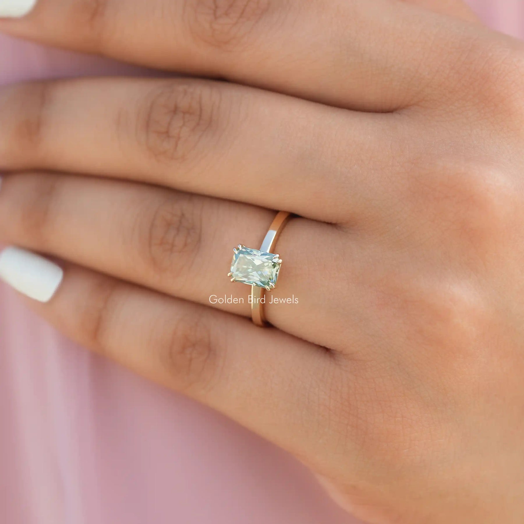 Close-Up View of Blue Radiant Cut Solitare Engagement Ring in a finger